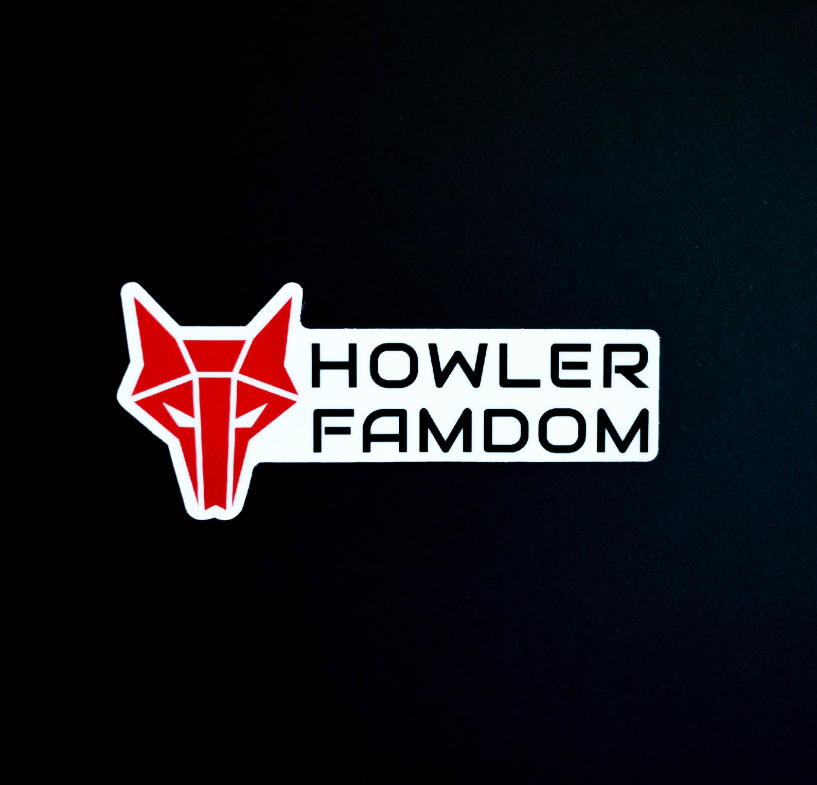 White sticker with red wolf Howler sigil and the words Howler Famdom in black