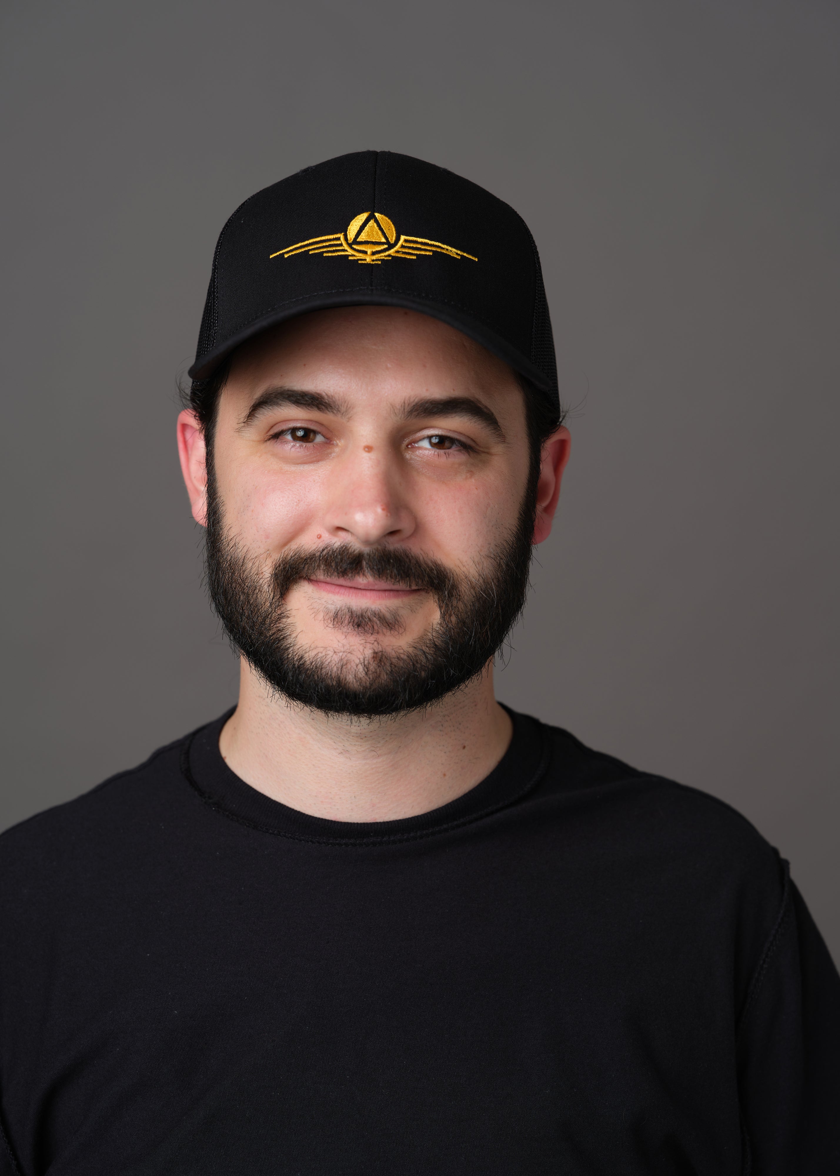 Black hat embroidered with the gold symbol of the rulers of the society