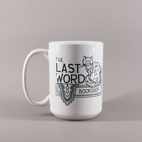 White mug that says The Last Word Bookshop and has a fluffy cat sitting next to books