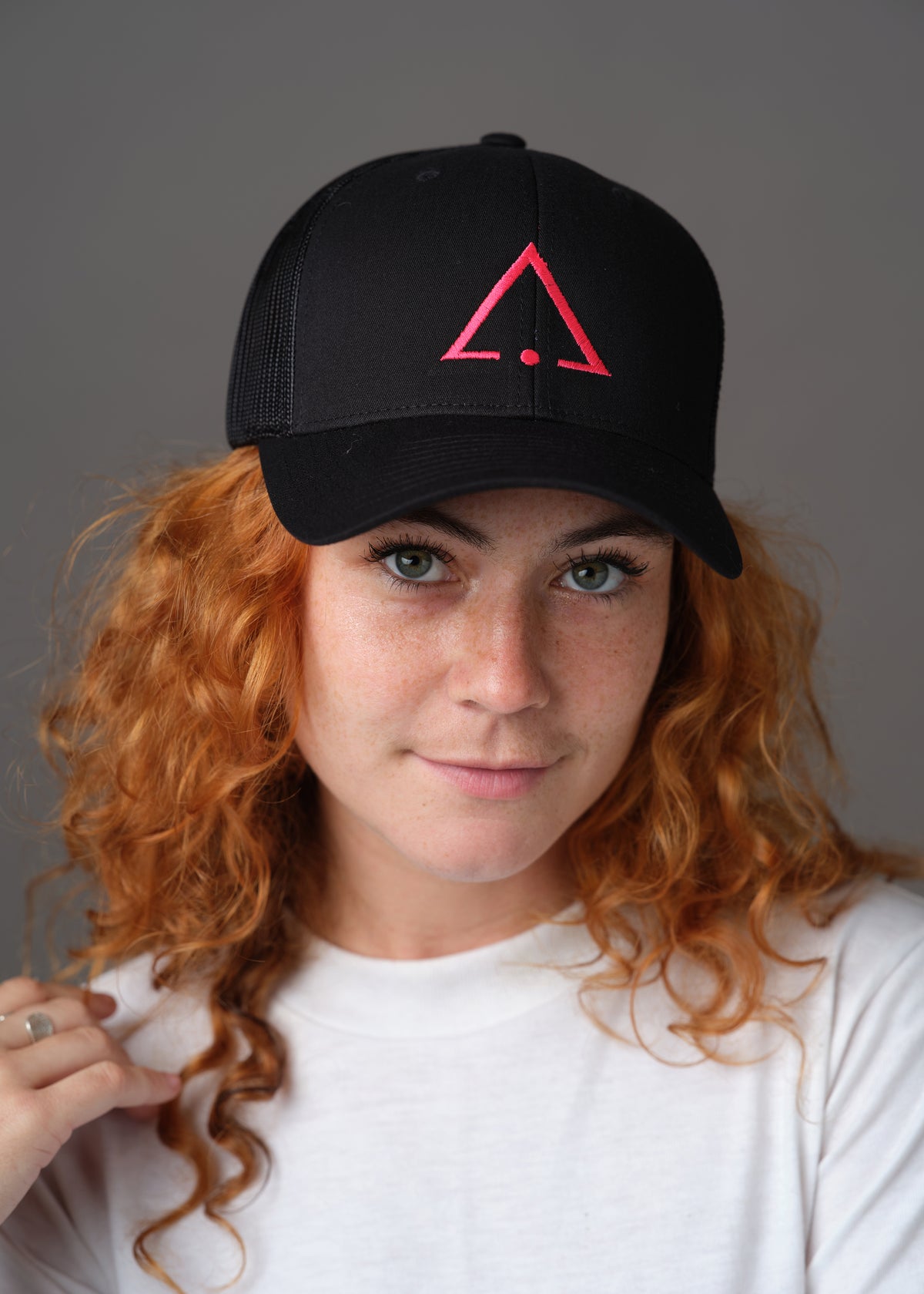 Black hat embroidered with the pink sigil of pleasure slaves and social functionaries