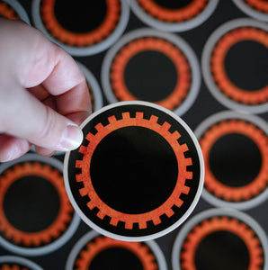 Black sticker with orange sigil of mechanics and engineers