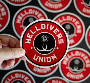 Round sticker with black white and red design with two white sling blades and a white star surrounded by the words Helldivers Union