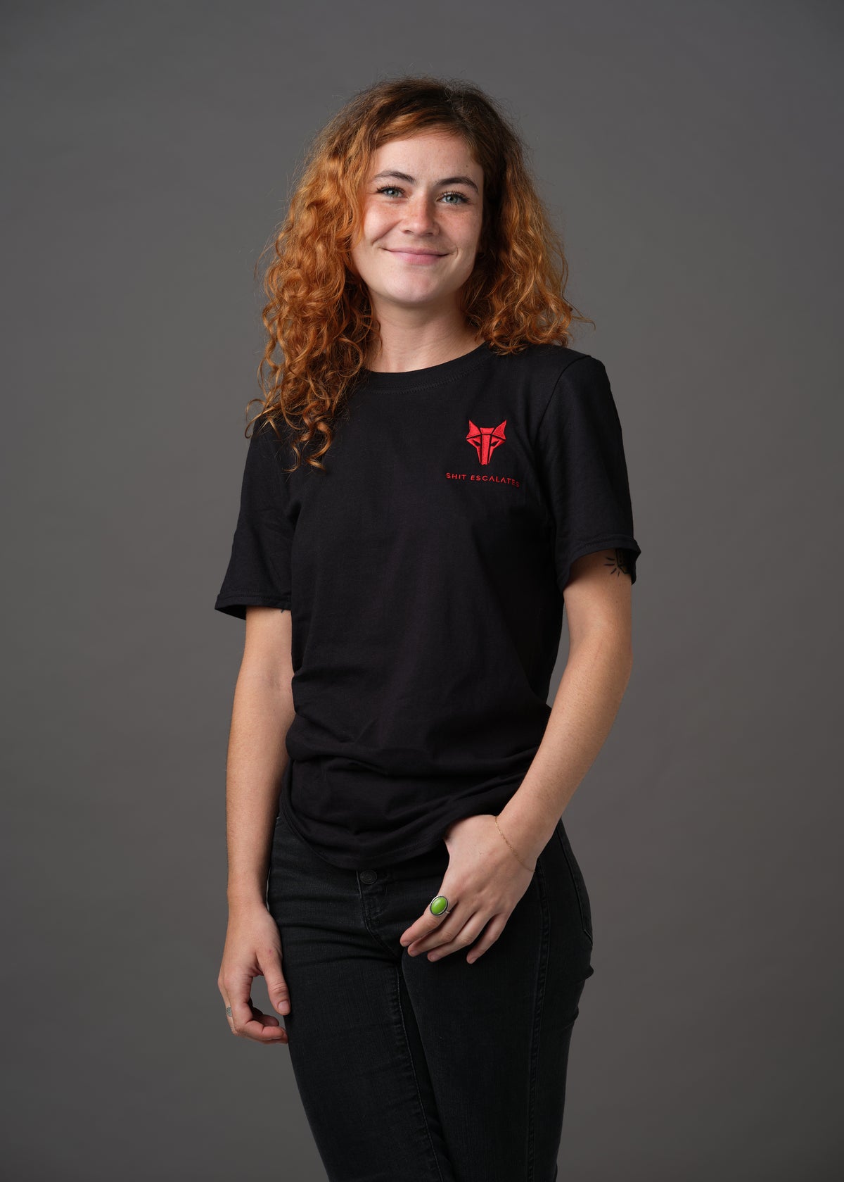 Black shirt with red Howler wolf sigil and 'Shit Escalates' embroidered below on left chest