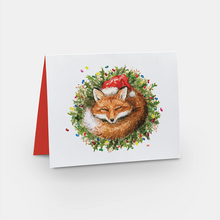 Load image into Gallery viewer, Card with white background and a red fox wearing a Santa hat curled up in a green wreath covered in jellybeans 
