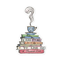 Load image into Gallery viewer, Sticker depicting a steaming tea cup and saucer on top of a stack of books that say &quot;Books, she has found, are a way to live a thousand lives.&quot;
