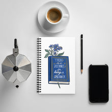 Load image into Gallery viewer, Spiral notebook with white background, blue flowers in a book that says &quot;there is a defiance in being a dreamer&quot;
