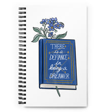 Load image into Gallery viewer, Spiral notebook with white background, blue flowers in a book that says &quot;there is a defiance in being a dreamer&quot;
